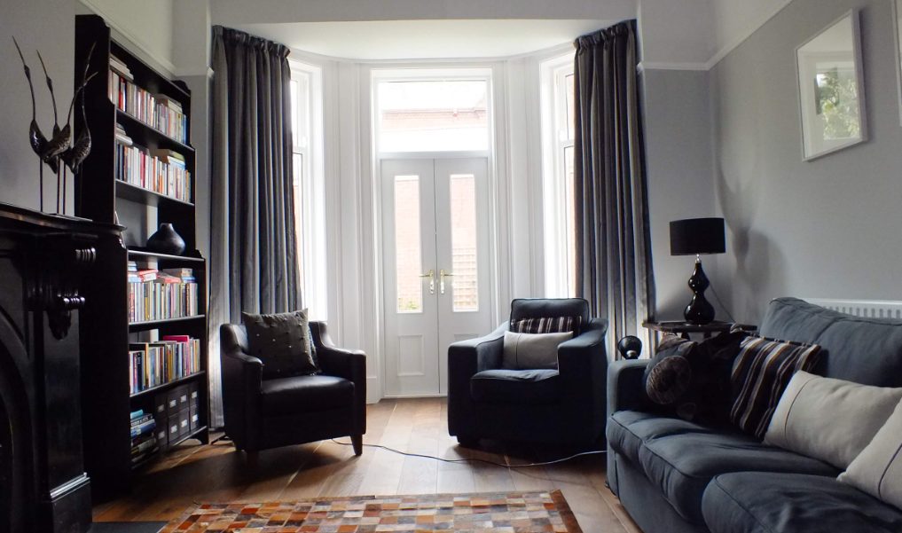 Bright living room with dark furniture and dark grey curtains