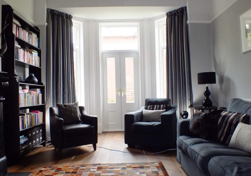Bright living room with dark furniture and dark grey curtains